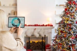 Young woman using application in her smart home at Christmas.