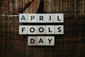Scrabble tiles spelling April Fools Day on a dark wood background
