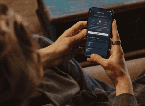 Woman with an Oura Ring looking at the new Symptom Radar settings in the Oura app.