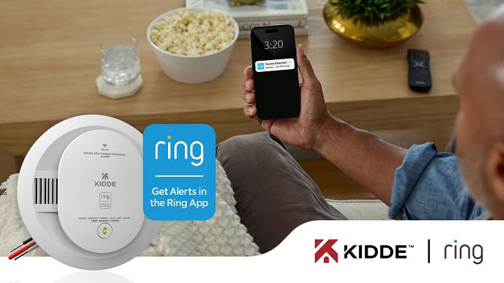 Kidde and Ring new smart Smoke and CO detector with person holding a cell phone showing a smoke detected alert.