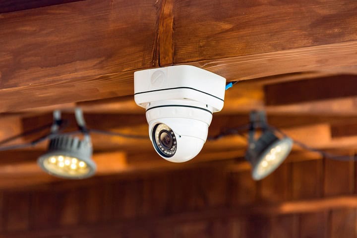 Close up of CCTV security camera on patio ceiling.